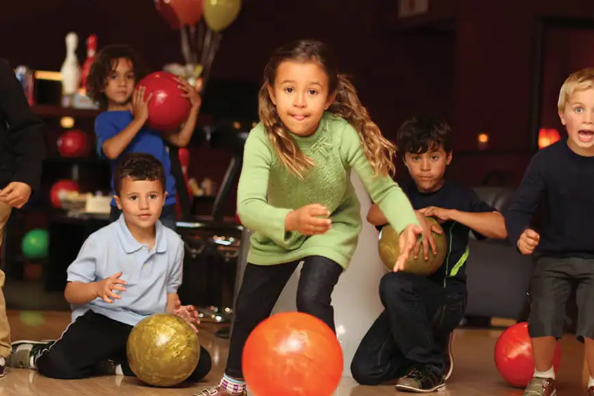 Kids Party - Young girl bowling while friends watch and cheer at Pro Bowl West in Fort Wayne, IN