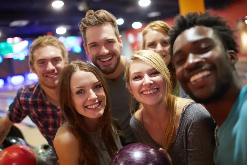 Group of friends smiling together while bowling at Pro Bowl West in Fort Wayne, IN as part of Ultimate Unlimited Party Package